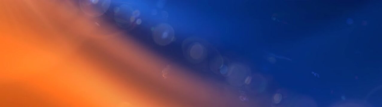 Blue and amber light forms a gradient across the frame with bright circular lens flares providing a soft bokeh effect.