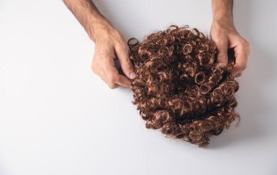 Male hand showing beautiful wig.