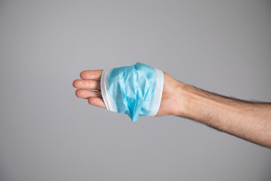 Caucasian man holding a medical mask.