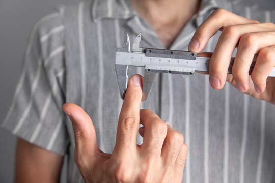 Man with a caliper measuring hand.