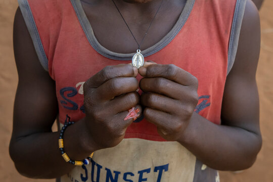 Boy holding a religious pendant necklace, Bekopaka, Madagascar