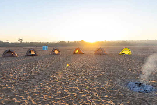 Row of camping tents on a sandbank at sunrise, Tsiribihina, Madagascar