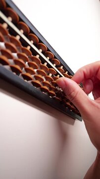 Slow-motion fingers calculating on an abacus.