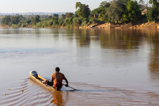 Man paddling a canoe away from the camera, Tsiribihina, Madagascar