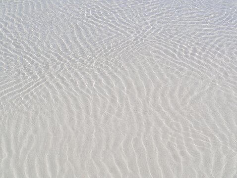 Clear water ripples on sandy surface