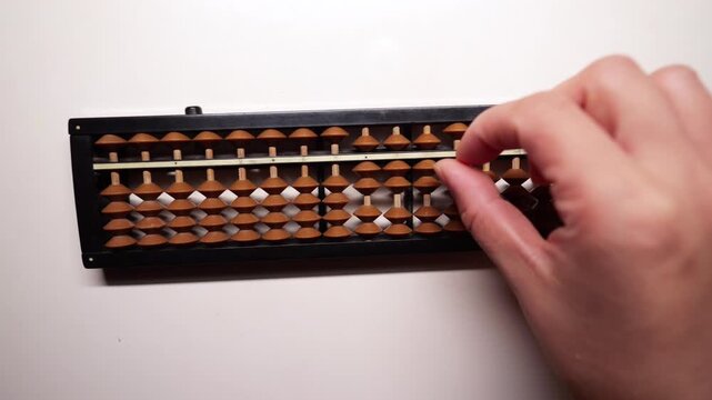 Slow-motion fingers calculating on an abacus.