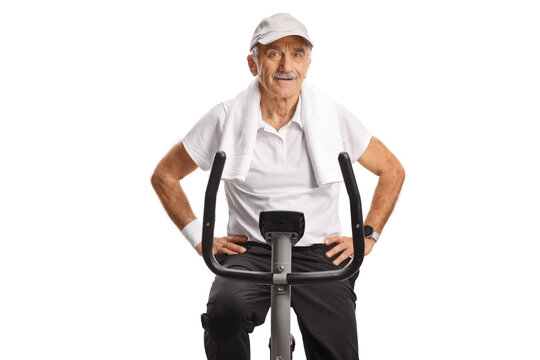 Elderly man with a towel around his neck sitting on a stationary exercise bike