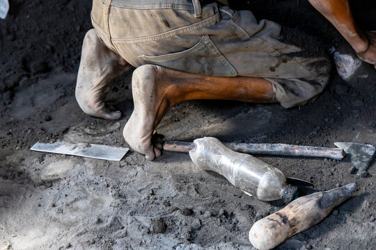 Foundry tools and bare feet on the ground, Ambatolampy, Madagascar