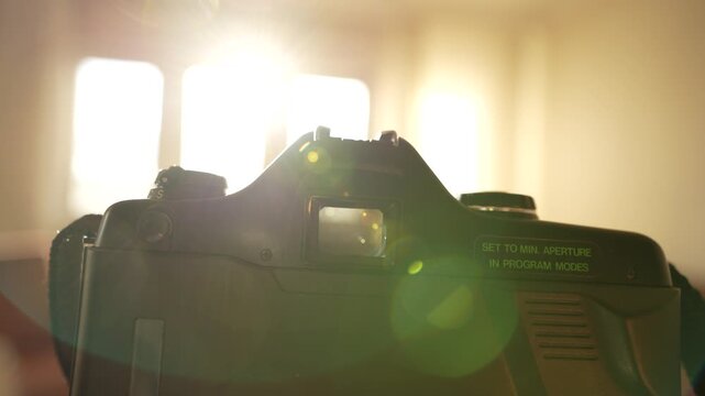 Taking photos inside the house with an analog camera. Close-up view of the camera from a POV perspective light leaks 

