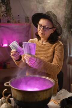 realistic witch counting money cash over cauldron brewing potion casting spells. Everyday life intertwined with traditional witchcraft, magic and mystical atmosphere.