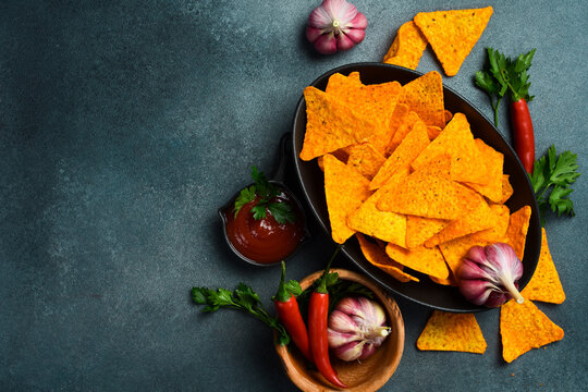 Crispy tortilla nachos chips served on a wooden board. This popular snack is universally loved.
