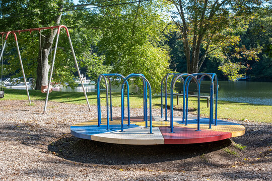 Playground merry go round in park near lake