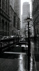 Fototapeta premium Gray Rainy Day at Subway Entrance Surrounded by Tall Buildings and White Skies in Urban City Scene