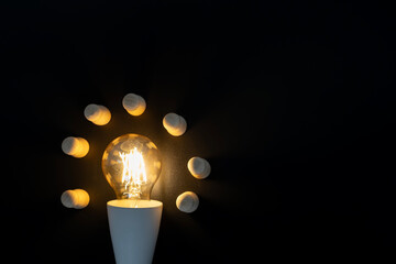 Glowing Edison-style bulb with wooden blocks around it © jittawit21