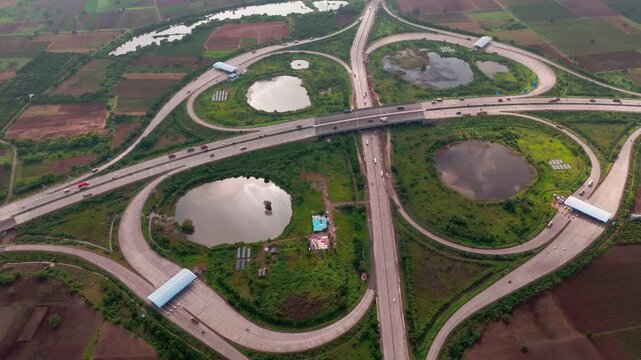 Aerial view of a complex highway interchange surrounded by rural fields and small ponds in Bharuch, Gujarat, India.