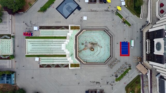Aerial view of the National Palace of Culture square with its large fountain, paved plaza, and surrounding urban architecture in Sofia, Sofia City Province, Bulgaria.