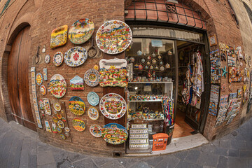 Obraz premium Siena, Tuscany, Italy - May 23, 2026: The facade of a traditional shop selling handicrafts, ceramics and souvenirs, in the historic center. 