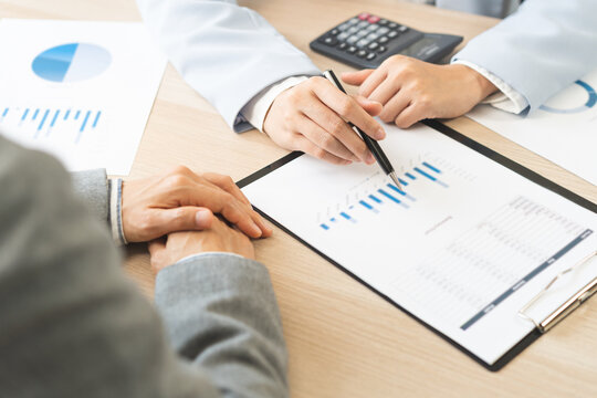 Business meeting, asian group brainstorm analysis on graph data of cost plan. financial consult planning investor asses and present to client, client and advisor review investment strategy in office.