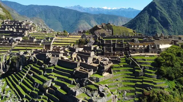 Aerial view of the ancient Inca citadel of Machu Picchu, featuring stone ruins, terraced fields, and surrounding Andean mountains in Urubamba Province, Cusco, Peru.
