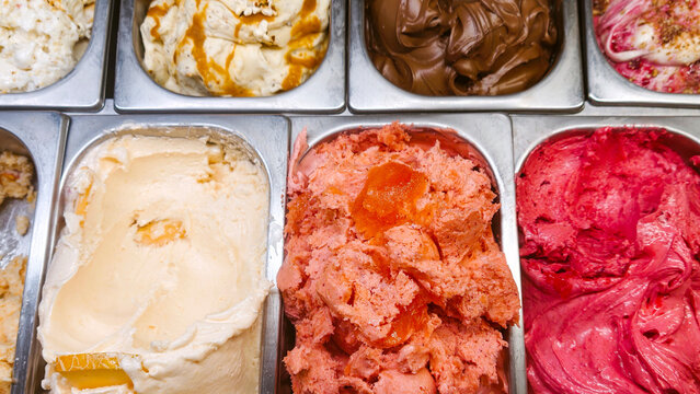 Artisan ice cream and gelato display featuring a colorful assortment of natural fruit flavors and rich creamy textures, a refreshing dessert for summer heat