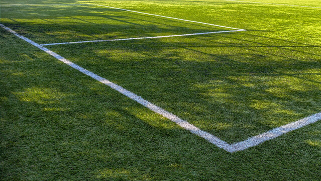Green artificial turf field showing white boundary lines, creating an athletic background for competition, teamwork, and active outdoor sport concepts