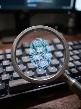 Fingerprint analysis with magnifying glass over keyboard digital security technology concept