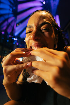 Woman Biting Into Burger Night