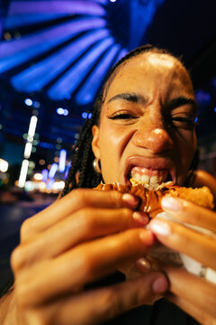 Woman Biting Into Fried Chicken
