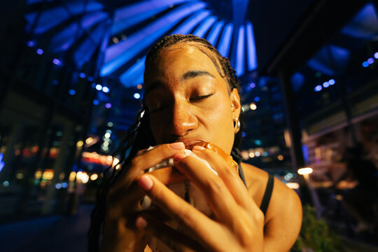 Woman Eating Burger at Night