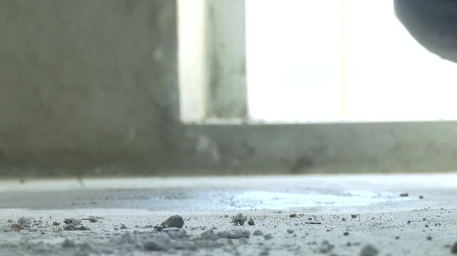 Screed flooring is processed in a residential building. A worker performs sand and cement screed floor over floor heating. Sand and cement floor screed. mason smooth the cement screed with trowel
