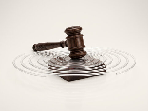 Concept of legal impact and court verdict showing wooden gavel hitting sound block with concentric wave ripples.