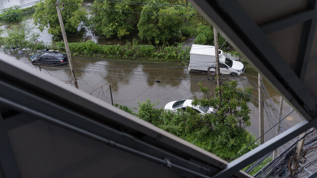 High angle view of a flooded residential street with submerged vehicles after heavy rainfall