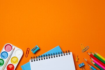 Flat lay with notebook and school stationery on orange background © Sunlight