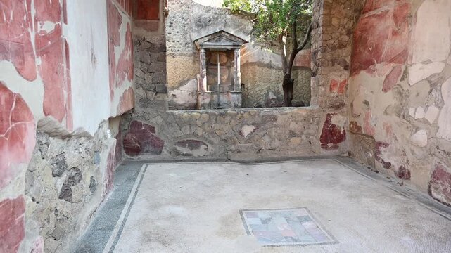 ERCOLANO, ITALY - SEPTEMBER 2026: Ancient Roman shrine lararium inside the courtyard of the House of the Carbonized Furniture in Herculaneum archaeological site.