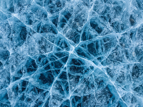 Frozen ice texture blue cracked pattern aerial view natural winter background detailed surface
