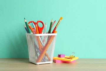 Holder with stationery on wooden table, closeup view. © Sunlight
