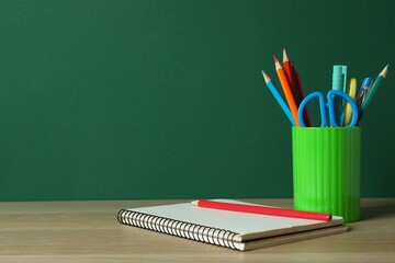 Green holder with stationery on table, closeup. © Sunlight