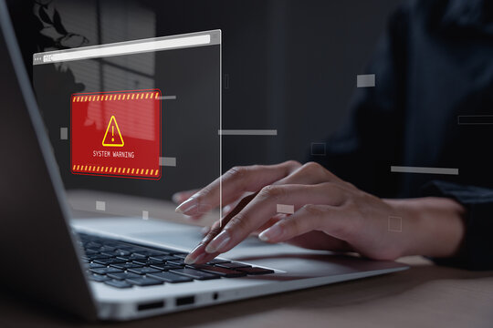 People using laptop with cybersecurity warning alert and data breach notification interface for online security protection, cyber attack prevention, ransomware risk and network defense.