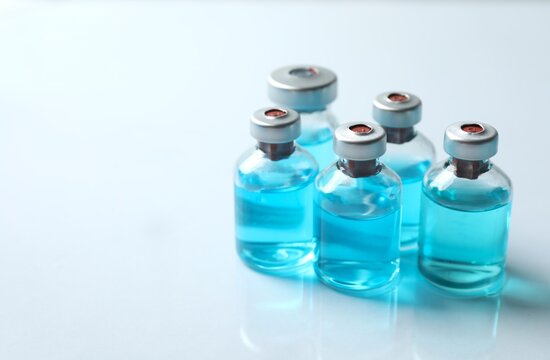 Small bottles with a blue liquid. Examples of vaccines and other medical equipment. Copy space