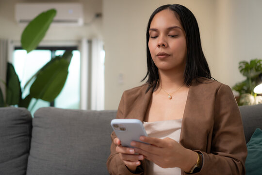 Woman meditating with eyes closed holding device