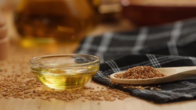 Flax oil pouring into glass bowl on flax seeds, golden flaxseed and linseed oil with omega 3, like sunflower, sesame or extra virgin olive oil, macro close up