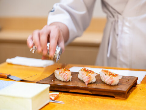 Sushi Chef Brushing Nikiri Sauce on Akami Tuna Nigiri Wooden Plate Chef Saucing Akami Nigiri Front