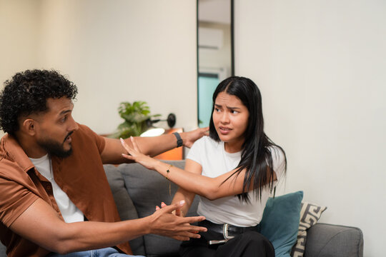 Young couple discussing problems at home, woman looking distressed