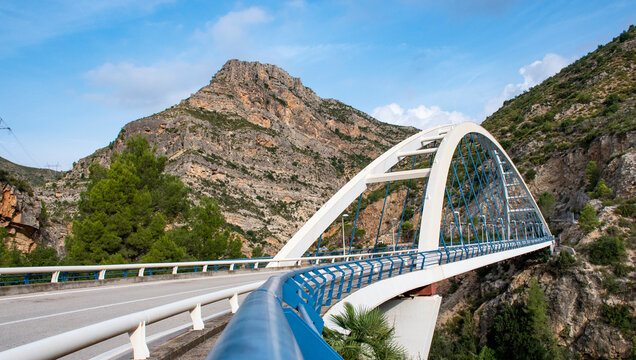 Puente arqueado moderno entre monta&ntilde;as rocosas y paisaje natural, r&iacute;o J&uacute;car en Valenciano  X&uacute;quer a su paso por Millares Comunidad Valenciana.