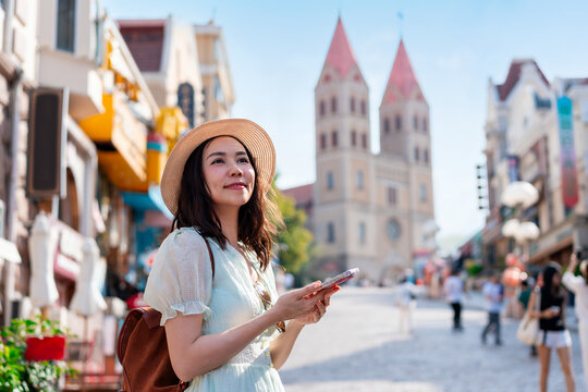 Solo traveler woman exploring city landmark with phone, travel and vacation lifestyle