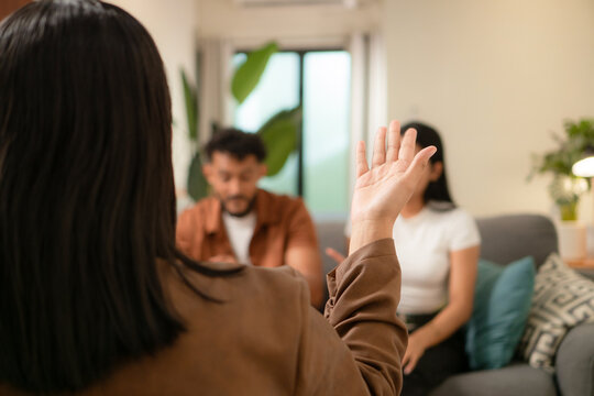 Counselor providing guidance to young adult couple during therapy session