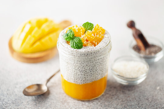 Chia seed pudding from coconut milk with mango puree and cubes  in glass jar. Vegan  food. Clean eating concept