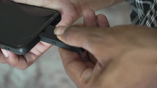 Person plugging a card reader or pen drive into smartphone port