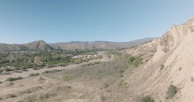 Aerial view of an eroded bluff and dry riverbed in a valley