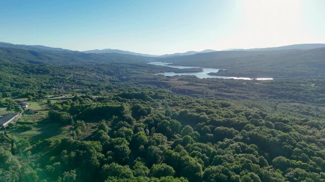 Aerial view of As Conchas reservoir and dense green forest in Ourense